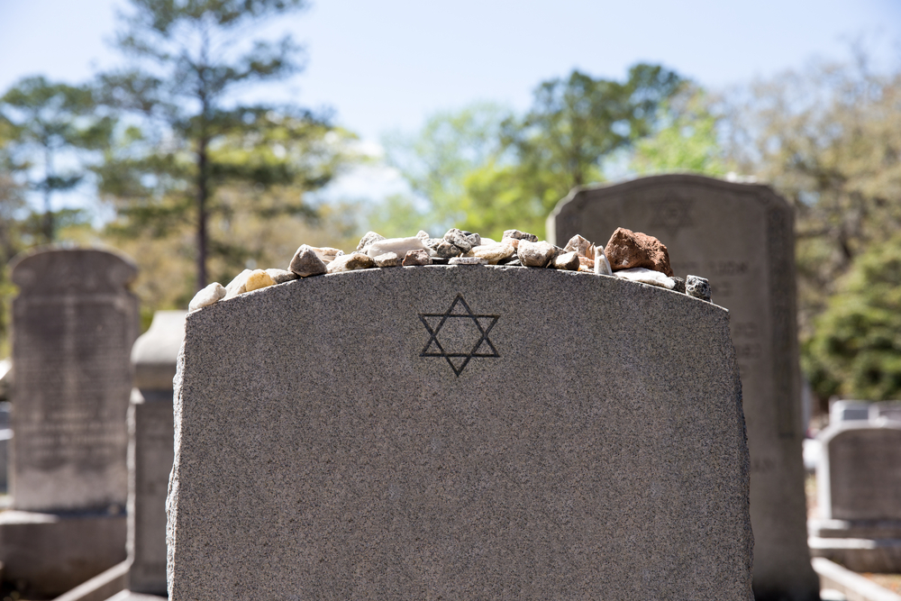 Headstone in a Jewish cemetery with Star of David and memory stones